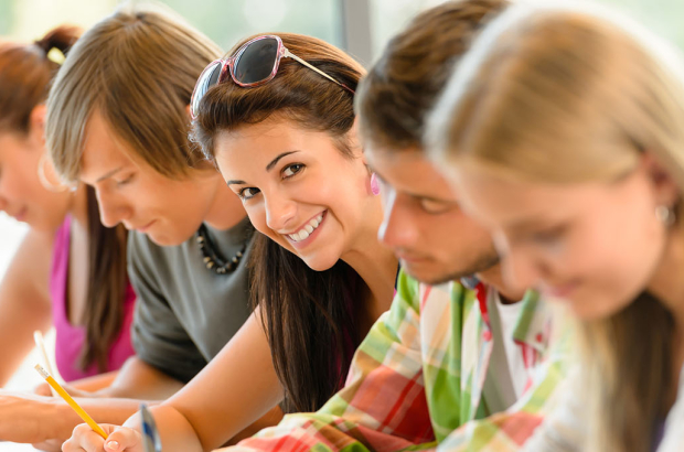 Students writing at high-school exam teens study campus academic class