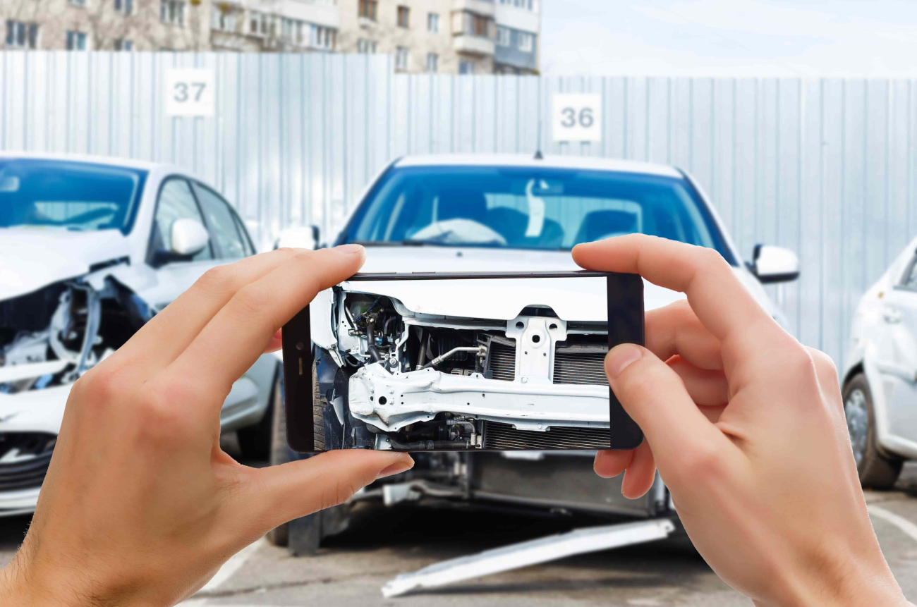 man_photographing_his_vehicle_with_damages_accident_insurance_with