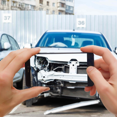 man_photographing_his_vehicle_with_damages_accident_insurance_with