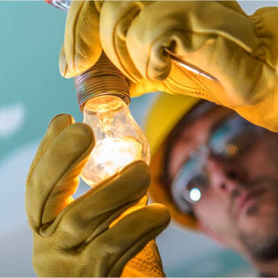 close-up-man-repairing-illuminated-light-bulb 1-min