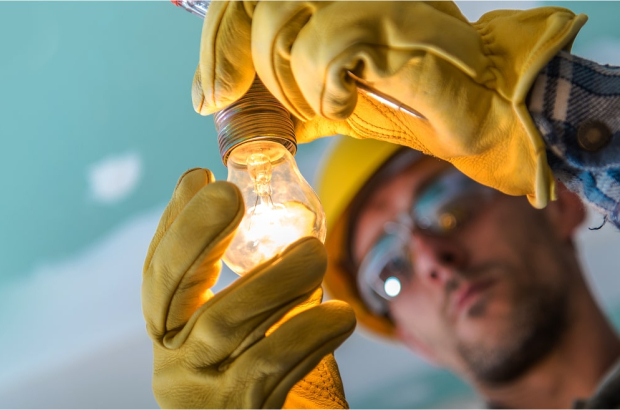 close-up-man-repairing-illuminated-light-bulb 1-min