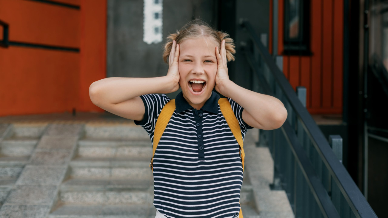 A charming schoolgirl holds her head, can't cope with stress and emotions.