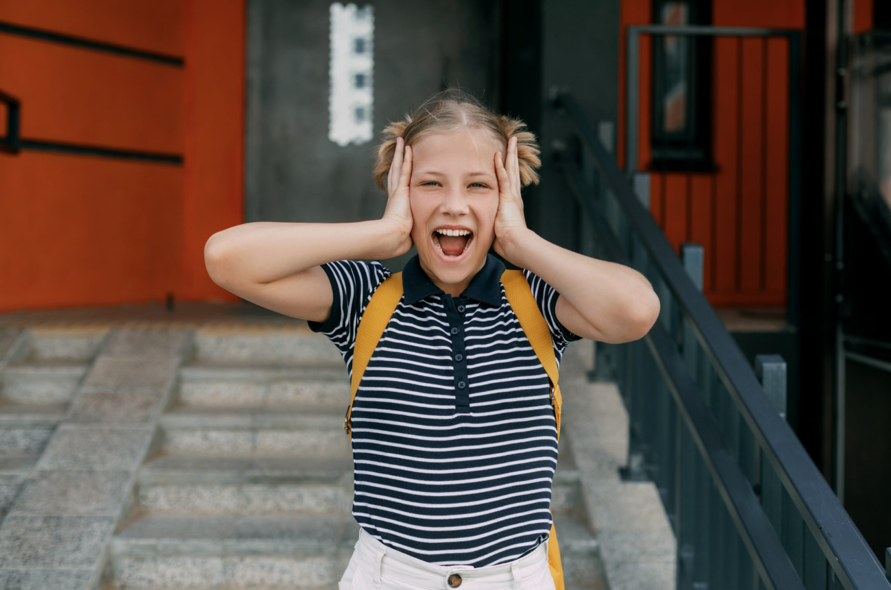 A charming schoolgirl holds her head, can't cope with stress and emotions.