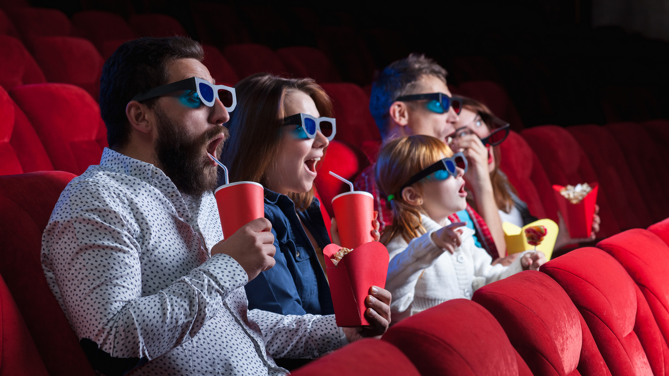 A variety of human emotions of friends holding a cola and popcorn in the cinema.