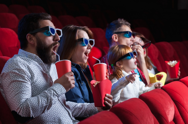 A variety of human emotions of friends holding a cola and popcorn in the cinema.