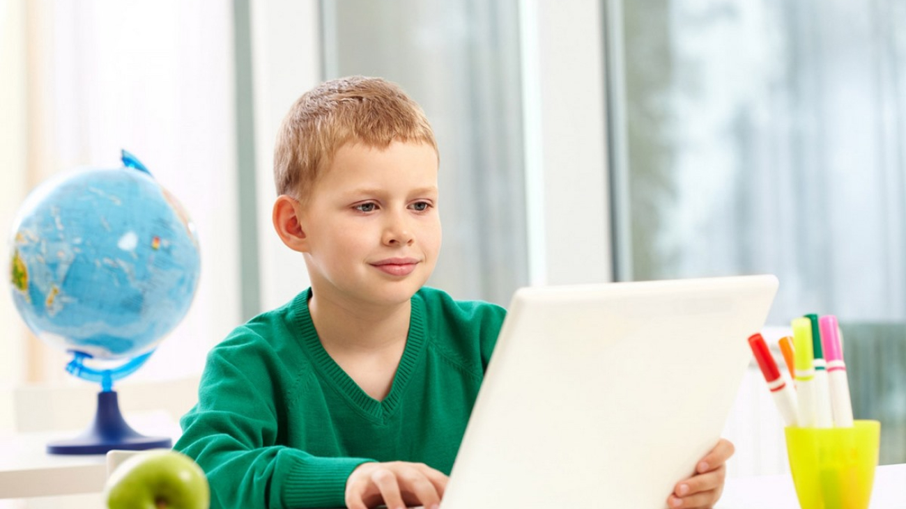 schoolboy-with-a-laptop-on-his-desk