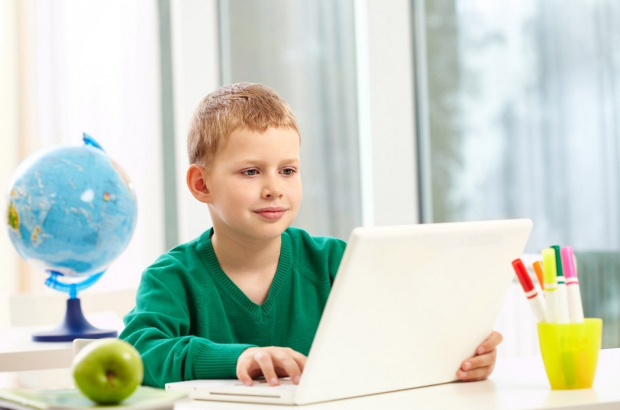 schoolboy-with-a-laptop-on-his-desk